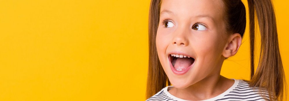 Portrait of happy excited amazed open mouth kid child girl look in copyspace isolated on yellow color background